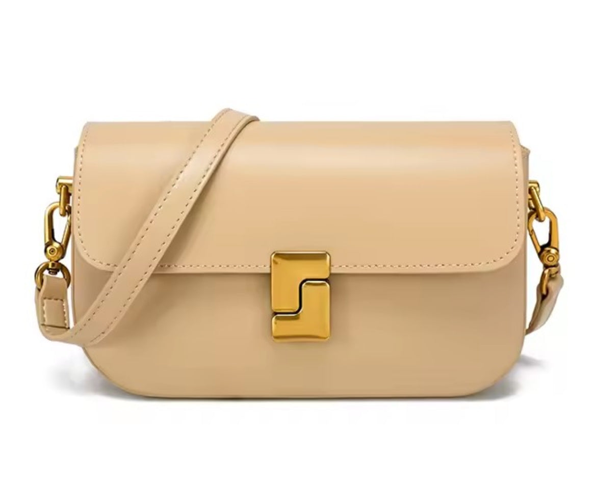 Beige handbag with gold hardware on a white background