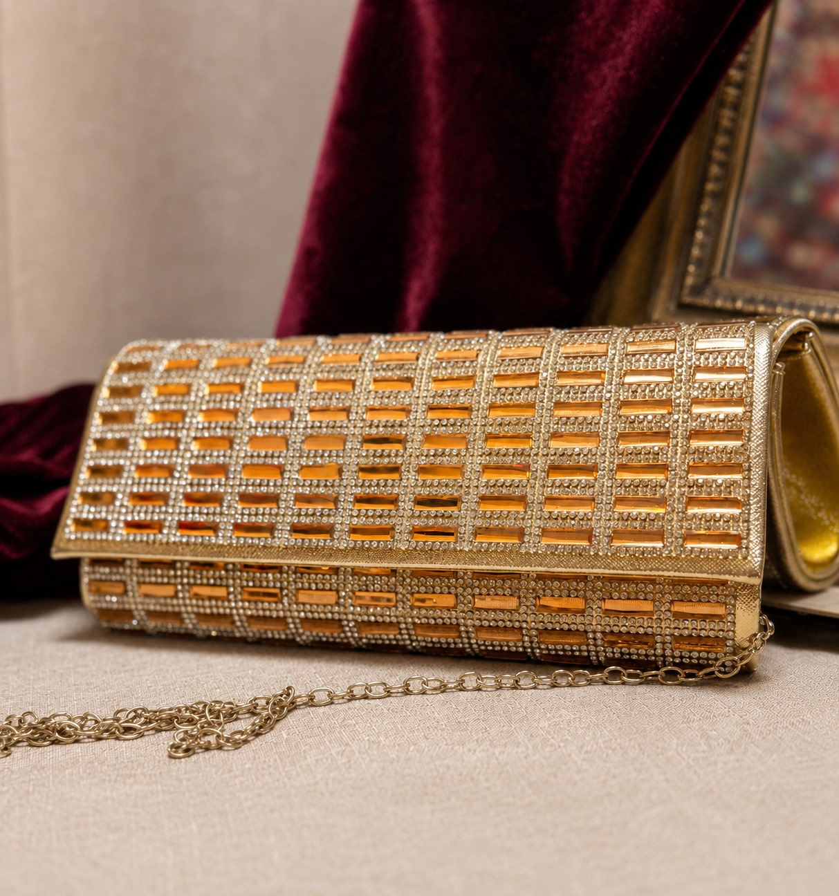 Gold clutch bag with intricate design on a neutral background